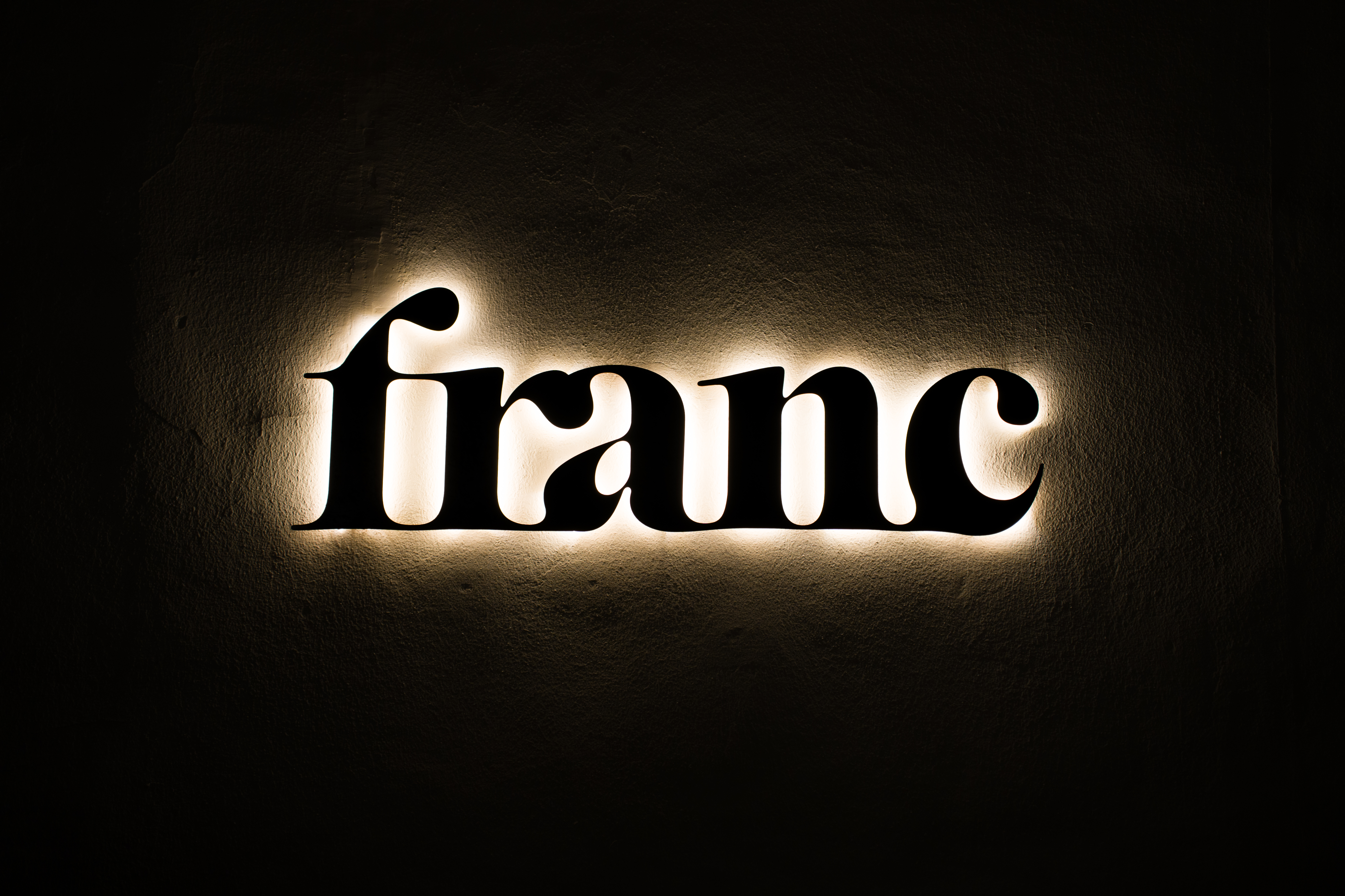 Back-lit Franc signage with warm halo