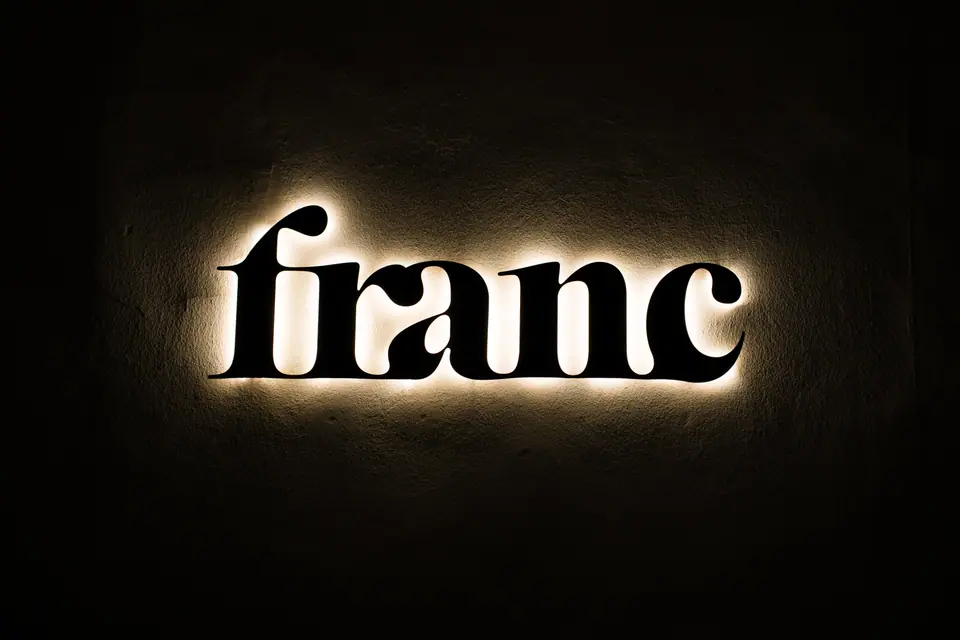 Back-lit Franc signage with warm halo