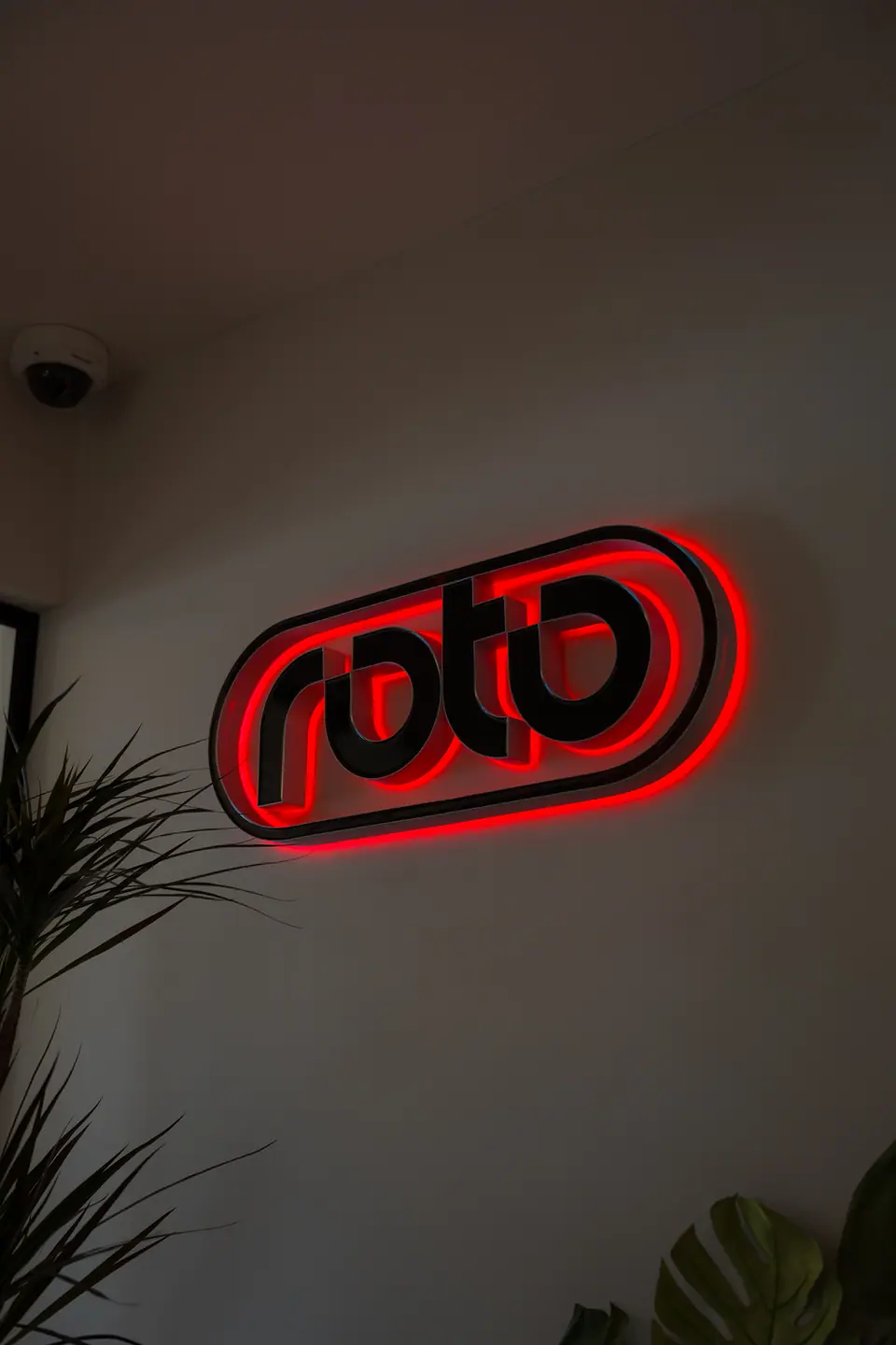Roto logo sign with red back glow on a dark wall