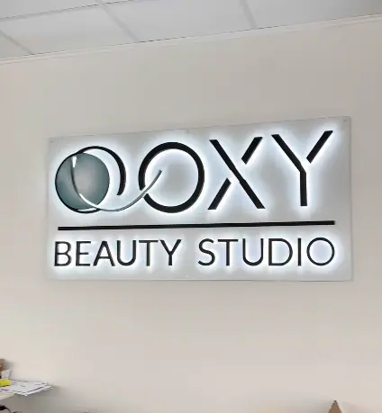 OOXY Beauty Studio back-lit sign